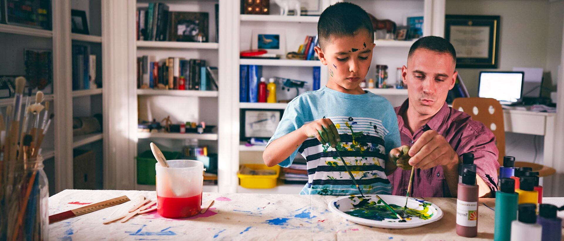 Student painting with his father